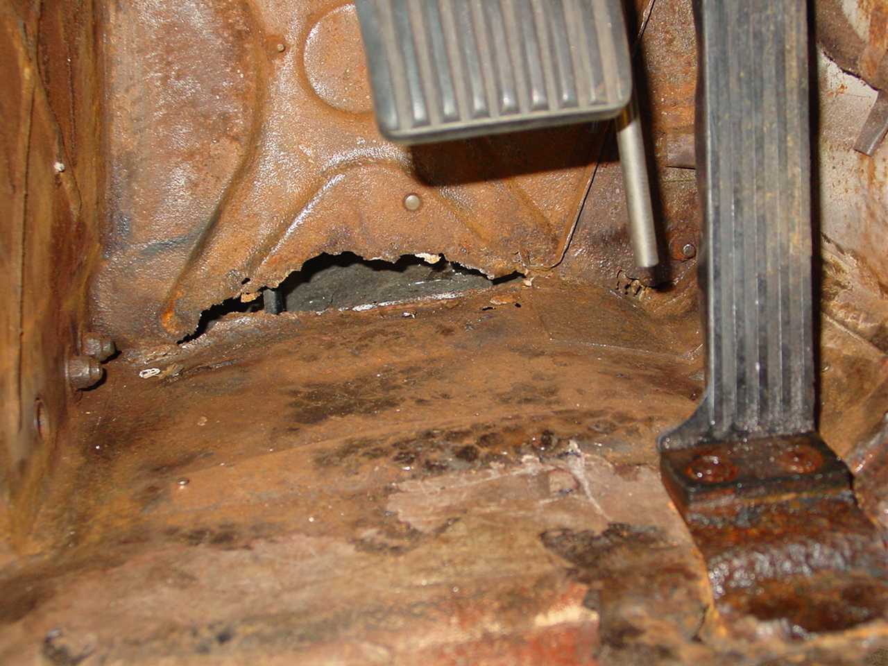 This rust hole was covered by a "flexible white bog" when car was purchased. Buyer beware indeed!